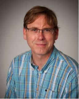 An image of Arnout Kalverda wearing a blue striped shirt and glasses.