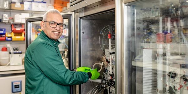 Scientist stood in front of equipment turning to face the camera