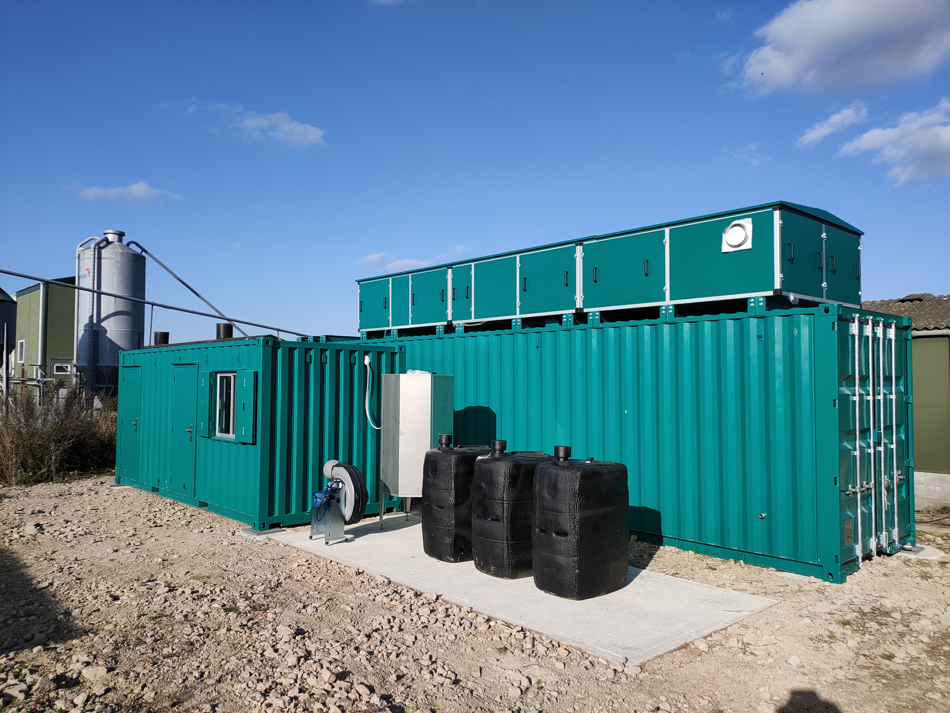 The insect bioreactor. It is a large green container made of congregated metal.
