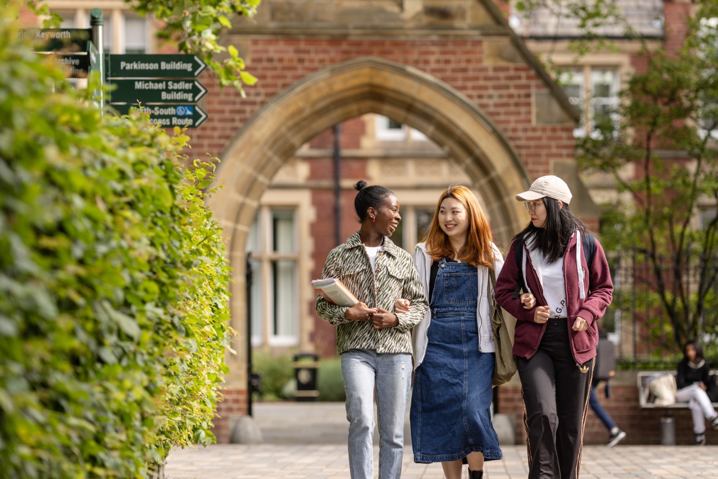 Three postgraduate students walk through the University of Leeds campus