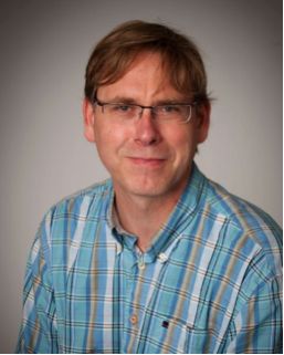 An image of Arnout Kalverda wearing a blue striped shirt and glasses.