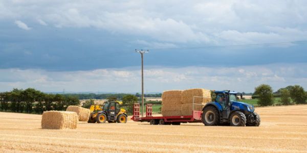 A tractor hay making in the sunshine on the University of Leeds farm
