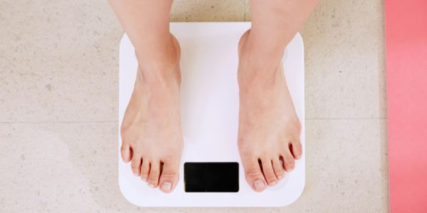 A person stands on weighing scales
