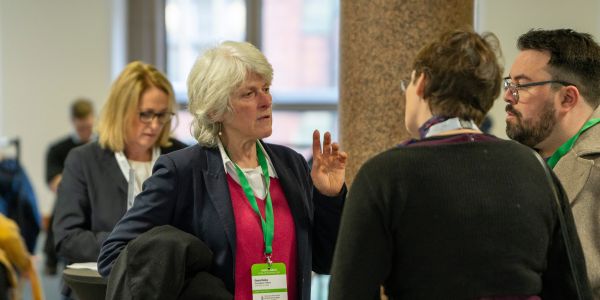 Dr gesa reiss speaks to a man and woman during the napic networking session