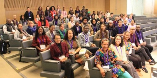 Members of the Black in Plant Science network sit in chairs smiling at the camera.