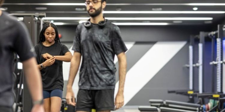 People in a gym setting with gym tech