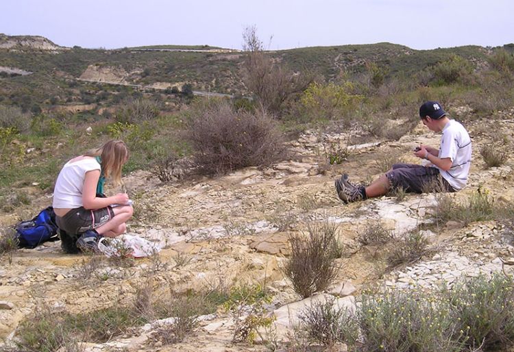 Students work on a research project together in a rocky environment