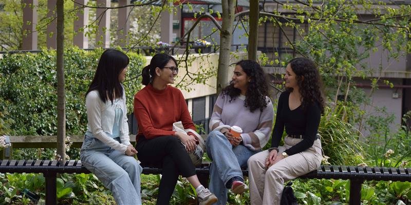 Four postgraduate students sat on campus